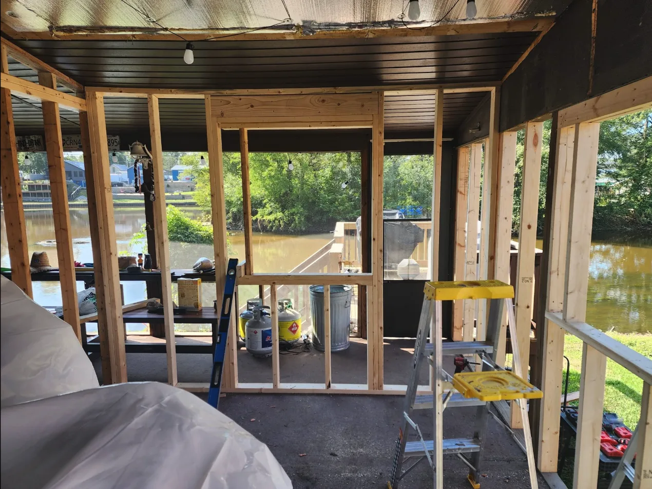 A lakeside porch enclosure we framed this summer — new walls, window openings, and a view worth keeping.